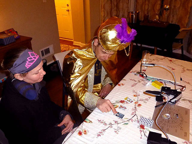 Mister Vibe wearing gold turban reading tarot cards for woman.