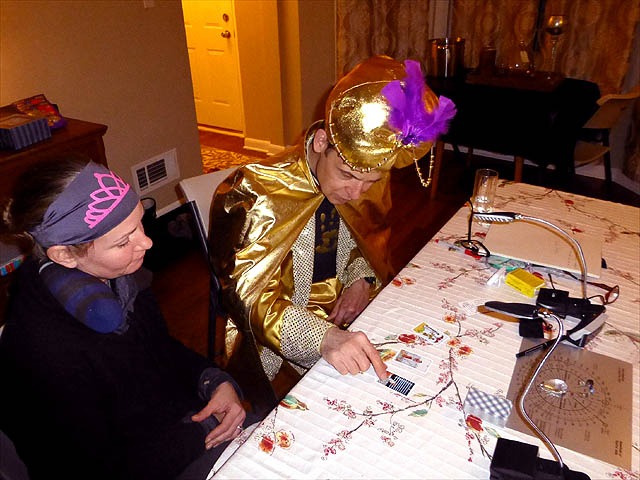 Mister Vibe wearing gold turban reading tarot cards for woman.