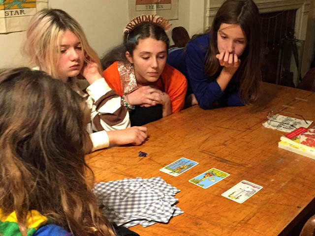 Teenage girls looking at tarot cards on a table. 